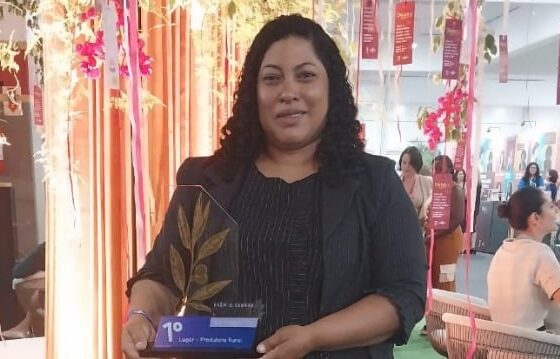 Mulher em pé segurando o troféu