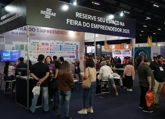 a foto mostra um estande do ano de 2024 com pessoas reunidas em volta do mesmo